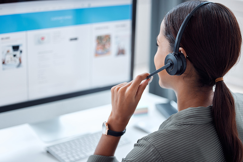 Virtual Receptionist with headset managing calls and using computer